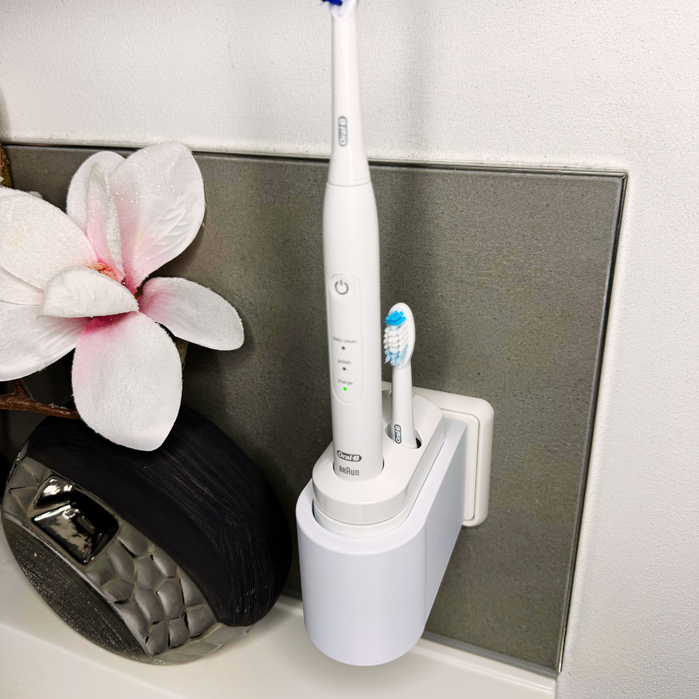 Oral B Pulsonic Smart Zahnbürstenhalterung die direkt in eine Steckdose eingesteckt ist.Die Halterung ist so gestaltet, dass keine Kabel sichtbar sind. Praktische Lösung, um die Zahnbürste aufzubewahren und gleichzeitig den Raum ordentlich zu halten.