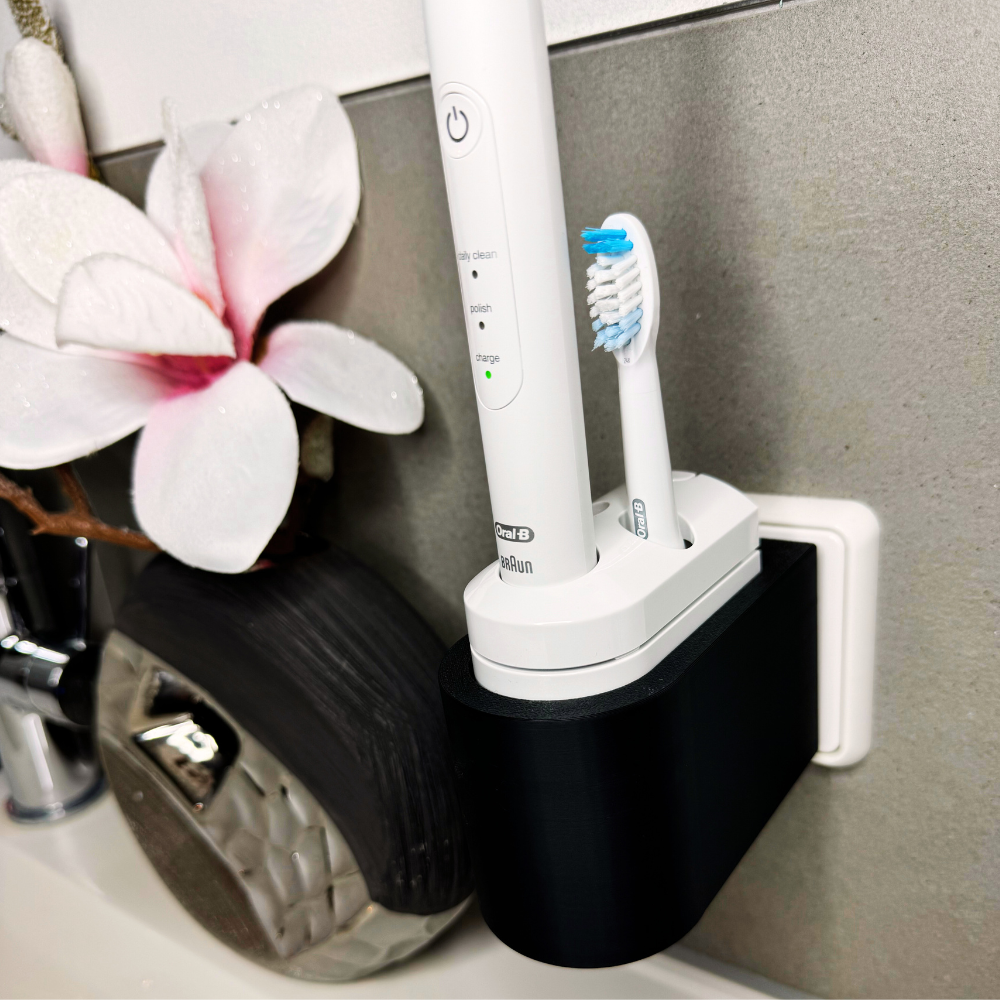 Oral B Pulsonic Smart Zahnbürstenhalterung die direkt in eine Steckdose eingesteckt ist.Die Halterung ist so gestaltet, dass keine Kabel sichtbar sind. Praktische Lösung, um die Zahnbürste aufzubewahren und gleichzeitig den Raum ordentlich zu halten.