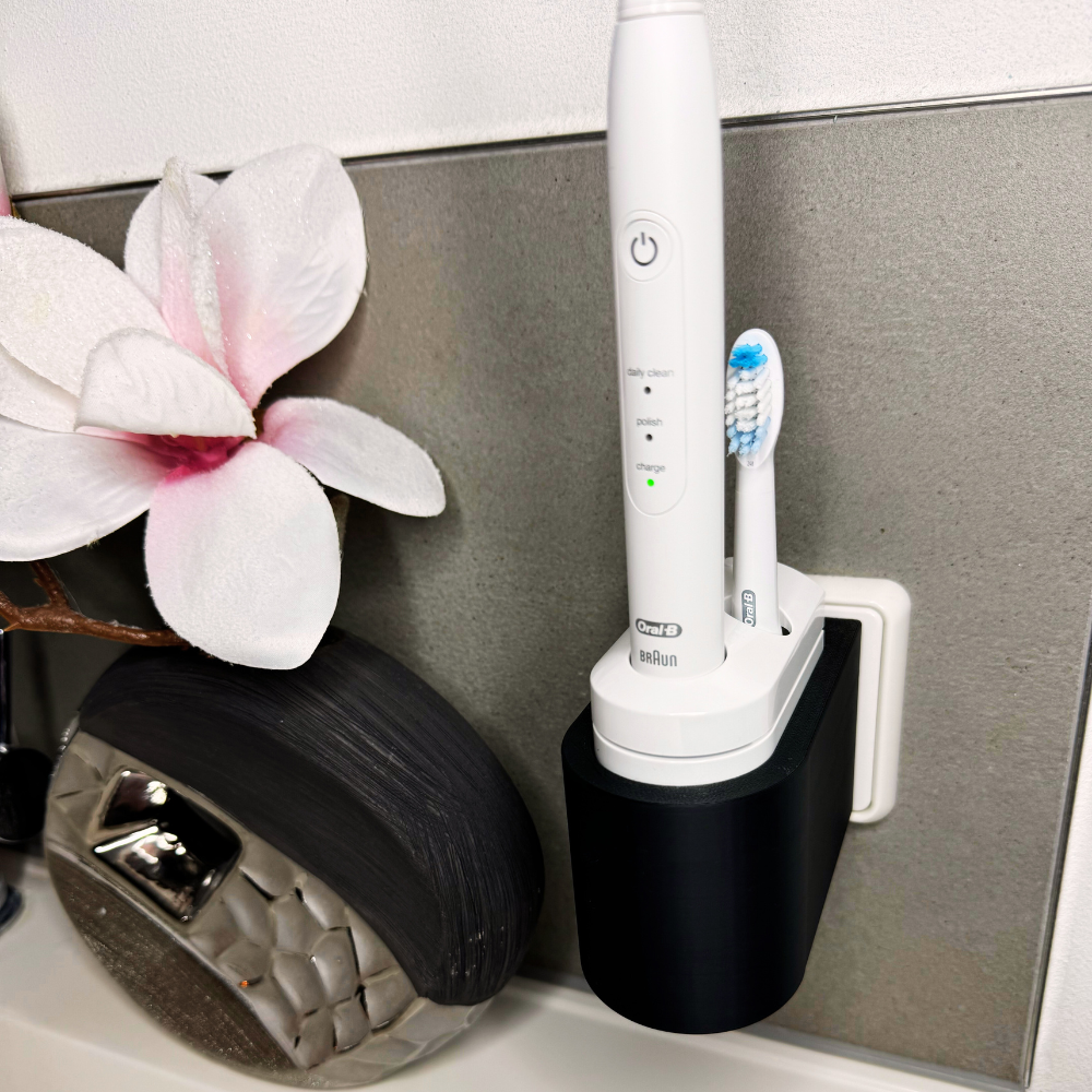 Oral B Pulsonic Smart Zahnbürstenhalterung die direkt in eine Steckdose eingesteckt ist.Die Halterung ist so gestaltet, dass keine Kabel sichtbar sind. Praktische Lösung, um die Zahnbürste aufzubewahren und gleichzeitig den Raum ordentlich zu halten.