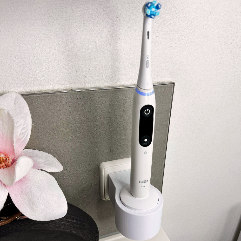 Oral B IO 7,8,9 Zahnbürstenhalterung die direkt in eine Steckdose eingesteckt ist.Die Halterung ist so gestaltet, dass keine Kabel sichtbar sind. Praktische Lösung, um die Zahnbürste aufzubewahren und gleichzeitig den Raum ordentlich zu halten.