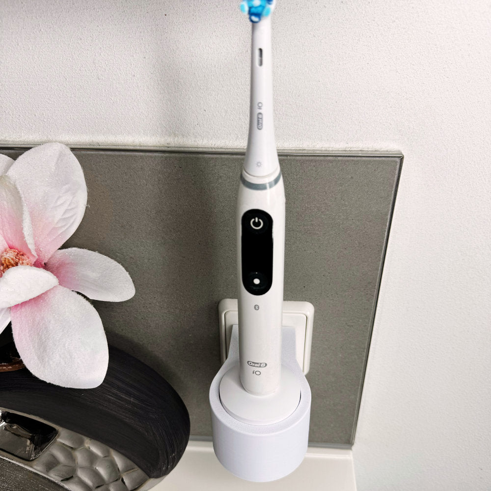 Oral B IO 7,8,9 Zahnbürstenhalterung die direkt in eine Steckdose eingesteckt ist.Die Halterung ist so gestaltet, dass keine Kabel sichtbar sind. Praktische Lösung, um die Zahnbürste aufzubewahren und gleichzeitig den Raum ordentlich zu halten.