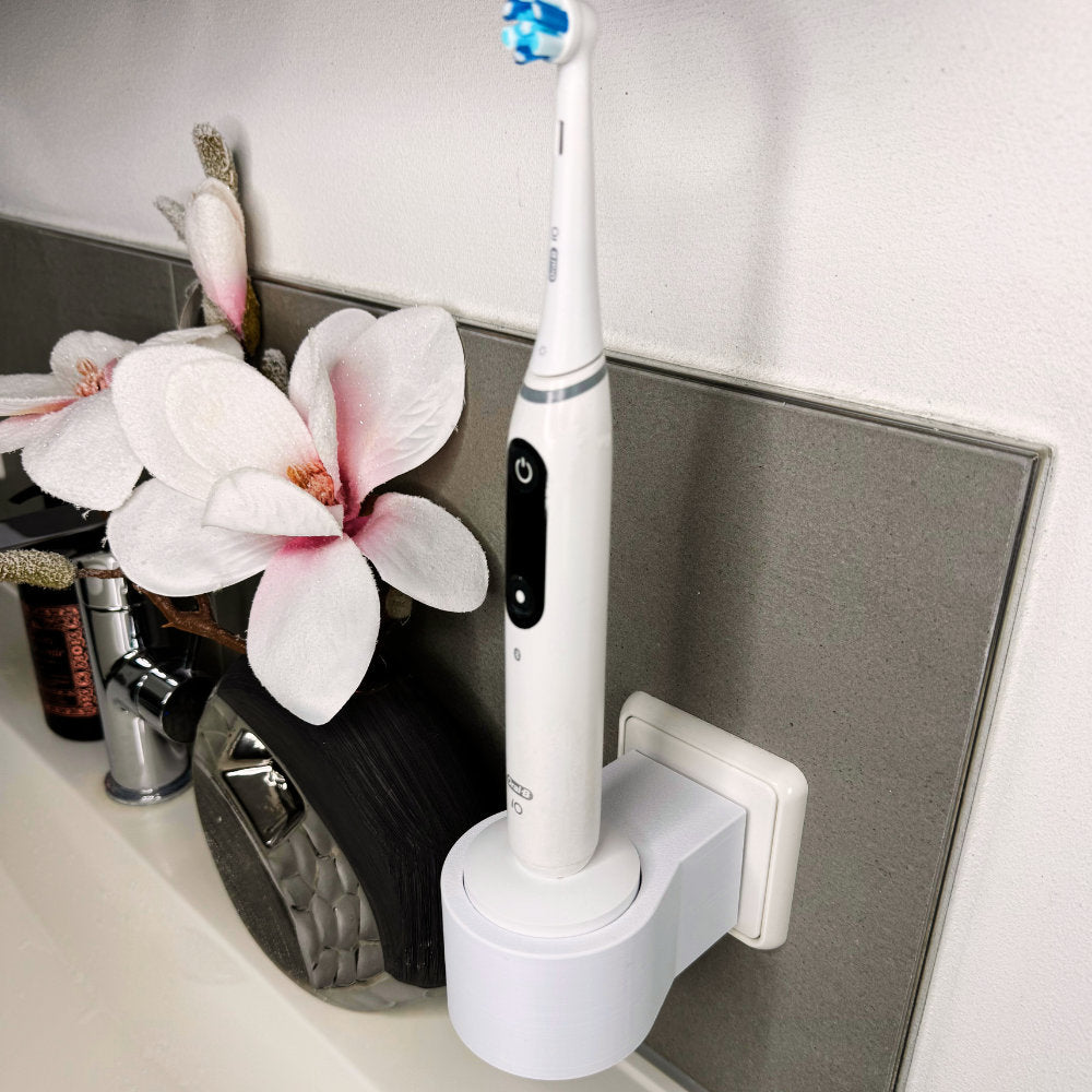 Oral B IO 7,8,9 Zahnbürstenhalterung die direkt in eine Steckdose eingesteckt ist.Die Halterung ist so gestaltet, dass keine Kabel sichtbar sind. Praktische Lösung, um die Zahnbürste aufzubewahren und gleichzeitig den Raum ordentlich zu halten.