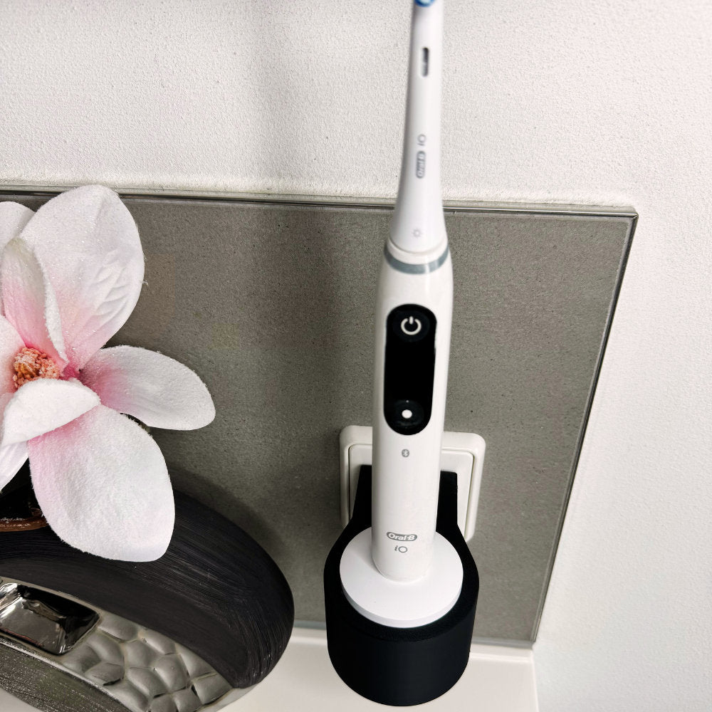 Oral B IO 7,8,9 Zahnbürstenhalterung die direkt in eine Steckdose eingesteckt ist.Die Halterung ist so gestaltet, dass keine Kabel sichtbar sind. Praktische Lösung, um die Zahnbürste aufzubewahren und gleichzeitig den Raum ordentlich zu halten.