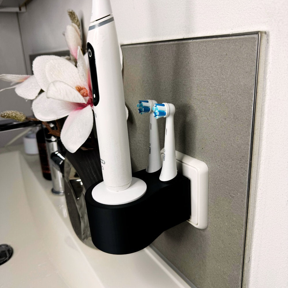 Oral B IO 7,8,9 Zahnbürstenhalterung die direkt in eine Steckdose eingesteckt ist.Die Halterung ist so gestaltet, dass keine Kabel sichtbar sind. Praktische Lösung, um die Zahnbürste aufzubewahren und gleichzeitig den Raum ordentlich zu halten.