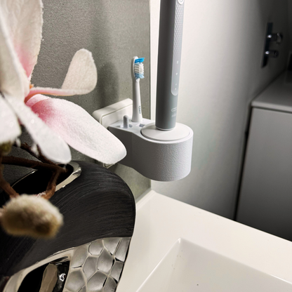 Oral B Pulsonic Slim Clean  Zahnbürstenhalterung die direkt in eine Steckdose eingesteckt ist.Die Halterung ist so gestaltet, dass keine Kabel sichtbar sind. Praktische Lösung, um die Zahnbürste aufzubewahren und gleichzeitig den Raum ordentlich zu halten.