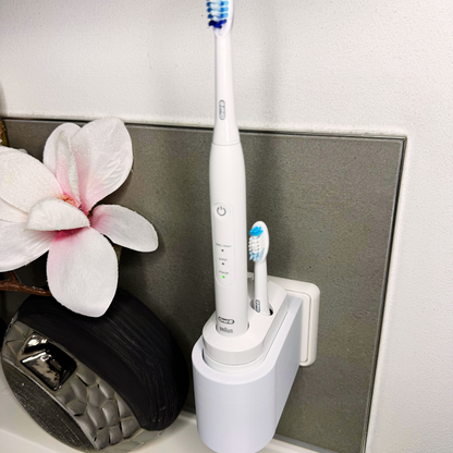 Oral B Pulsonic Smart Zahnbürstenhalterung die direkt in eine Steckdose eingesteckt ist.Die Halterung ist so gestaltet, dass keine Kabel sichtbar sind. Praktische Lösung, um die Zahnbürste aufzubewahren und gleichzeitig den Raum ordentlich zu halten.