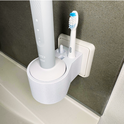 Oral B Pulsonic Slim Clean  Zahnbürstenhalterung die direkt in eine Steckdose eingesteckt ist.Die Halterung ist so gestaltet, dass keine Kabel sichtbar sind. Praktische Lösung, um die Zahnbürste aufzubewahren und gleichzeitig den Raum ordentlich zu halten.